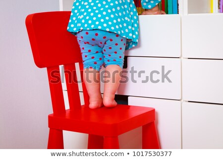 Stockfoto: Little Girl Climbing On A Chair