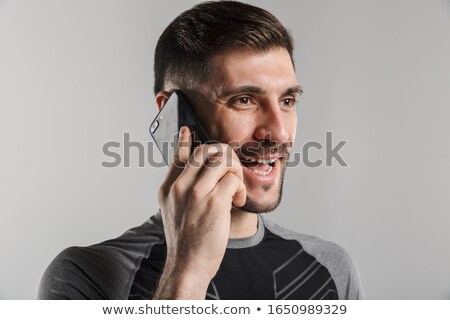 Stockfoto: Image Of Brutal Cheerful Sportsman Talking On Cellphone And Smiling