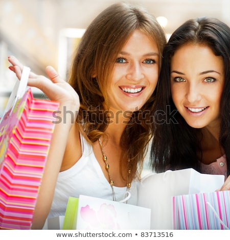 Foto stock: Two Excited Shopping Woman Resting On Bench At Shopping Mall Loo