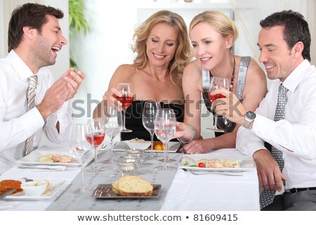 Stockfoto: Four Joyful People At The Start Of A Posh Dinner