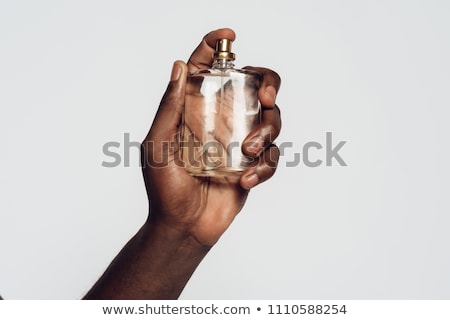 Foto stock: N · hombre · sostiene · una · botella · de · colonia