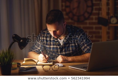 Foto stock: Man With Notepad Working At Night Office