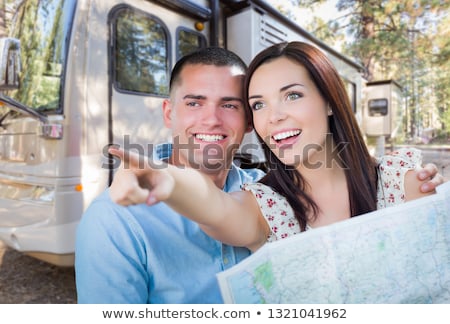 Foto stock: Young Military Couple Looking At Map In Front Of Rv