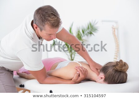 Stok fotoğraf: Physiotherapist Doing Females Back Massage In Clinic