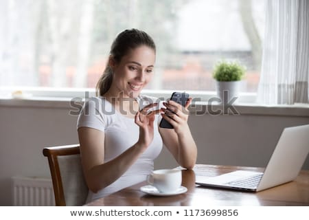 ストックフォト: Casual Female Reading News On Mobile Phone And Drinking Coffee