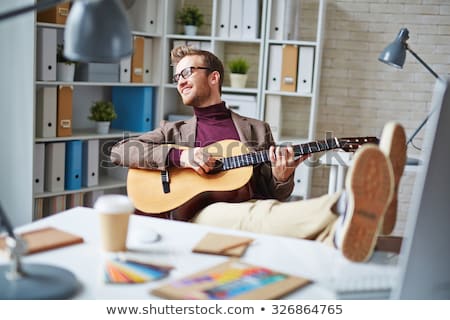 Man With Guitar In Office Stockfoto © Pressmaster