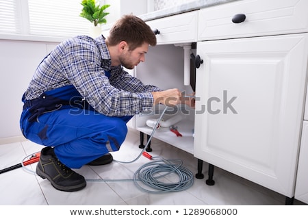 Stockfoto: Plumber Cleaning Clogged Sink Pipe