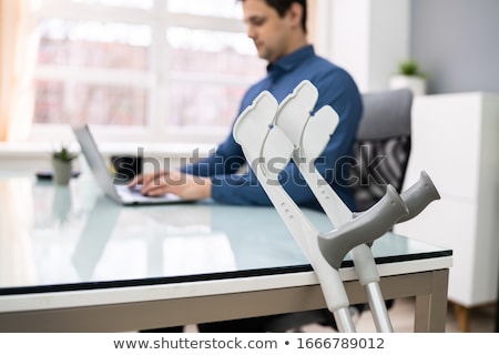 ストックフォト: Crutches Leaning On Table In Front Of Handicapped Patient