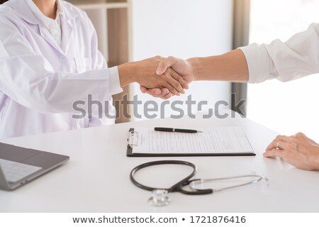 Foto d'archivio: Attractive Doctor And Patient Shaking Hands For Encouragement An
