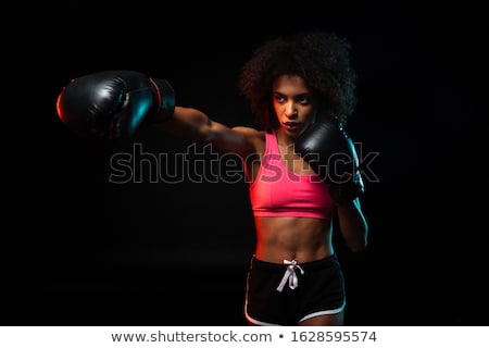 Foto d'archivio: Beautiful Woman Is Boxing On Black Background