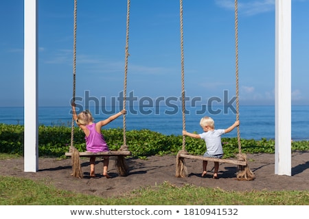 Stock photo: Two Little Blonde Boys Having Fun On The Swing On The Tropical Sandy Coast