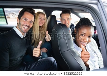 Zdjęcia stock: Friends Showing Thumbsup Gesture Sitting In Car