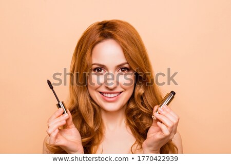 Foto d'archivio: Close Up Portrait Of Young Woman Applying Mascara To Her Eye