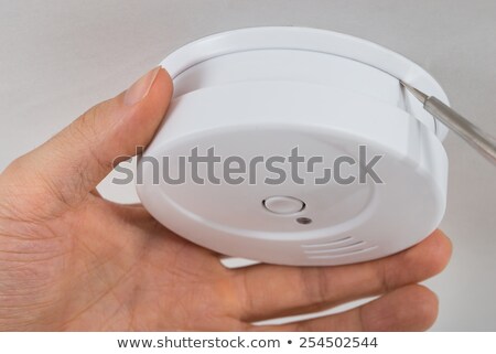 Foto d'archivio: Human Hand With Screwdriver And Smoke Detector