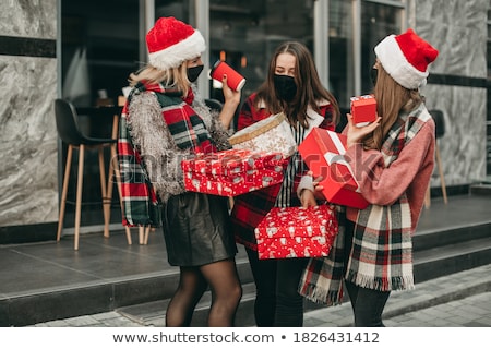 Stock fotó: Woman In Santa Hat Shopping For Christmas Gifts