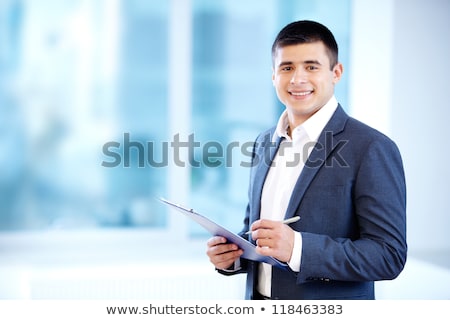 Stockfoto: Young Caucasian Businessman Writing On Clipboard