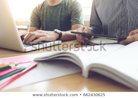 Stockfoto: Young Students Classmates Help Friend Catching Up Workbook And L
