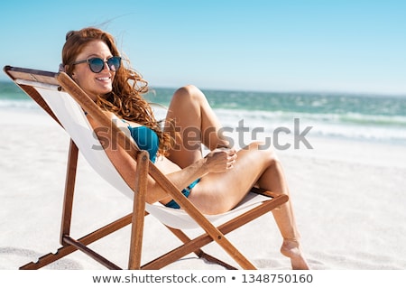 Foto d'archivio: Woman In Bikini Relaxing On Deck Chair