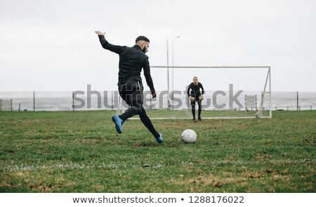 Foto stock: Soccer Player Kicking Ball Towards Goal Post