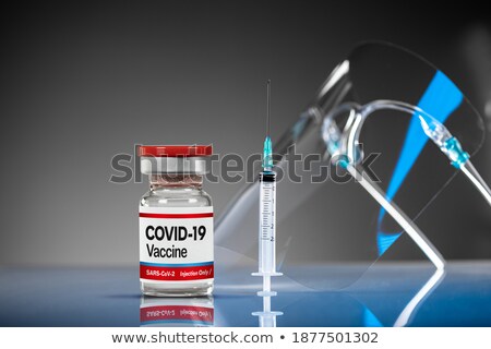 Foto stock: Coronavirus Covid 19 Vaccine Vials And Syringe On Reflective Sur