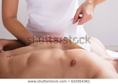 Stock fotó: Beautician Waxing Mans Chest With Wax Strip