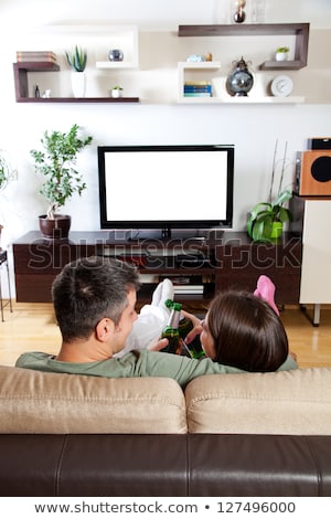 Foto stock: Relaxed Young Couple Watching Tv And Drinking Beer At Home