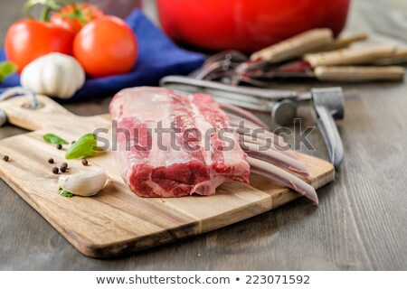 Сток-фото: Raw Lamb Rack With Some Tomatoes And Herbs In The Background