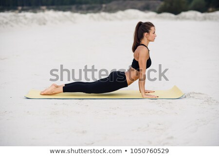 Stock fotó: Woman In Cobra Yoga Pose Meditating At Sunset Zen