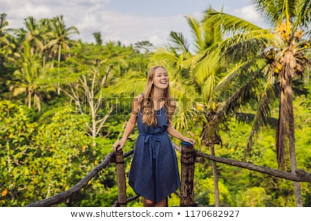 [[stock_photo]]: Young Woman Traveler On View Point In The Background Of A Jungle Bali Indonesia