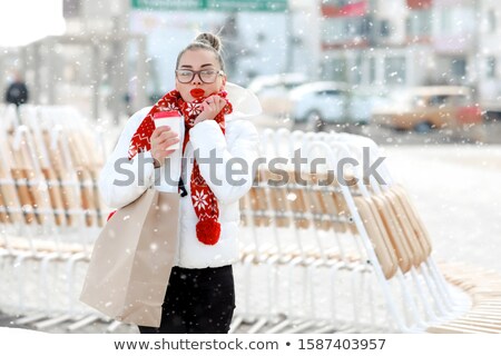 Stockfoto: Smilling Winter Girl In Knitted Warm Hat And Mittens Holding A Cup In Hands