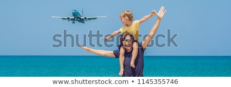 Stock fotó: Father And Son Have Fun On The Beach Watching The Landing Planes Traveling On An Airplane With Chil