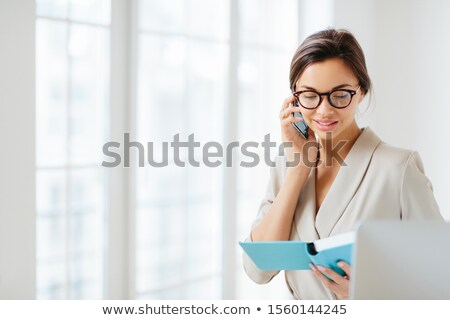 Stockfoto: Horizontal View Of Business Lady Discusses Working Schedule With Partner Via Modern Smartphone Make