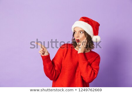 Foto stock: Woman In Santa Hat Pointing To Copyspace