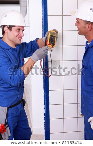 Foto stock: Two Young Plumbers Larking About With A Voltmeter