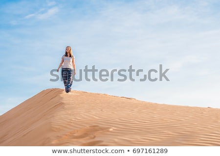 Foto stock: Young Woman In Rad Sandy Desert At Sunset