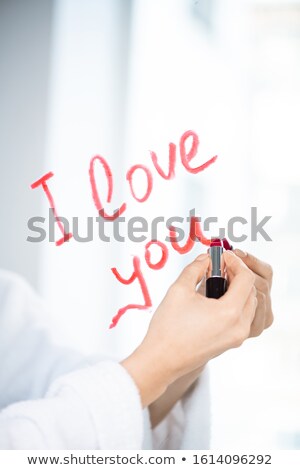 Stok fotoğraf: Hand Of Young Amorous Female Writing Love Message On Mirror With Lipstick