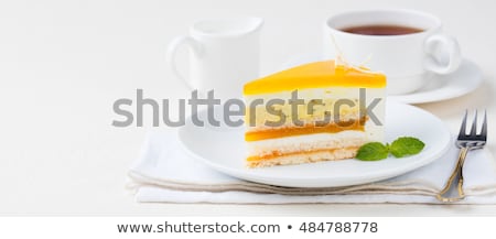 [[stock_photo]]: Passion Fruit Cake Mousse Dessert With Tropical Flavor On A White Plate With Cup Of Tea