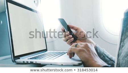 Stockfoto: Businessman With Smartphone And Laptop In Plane