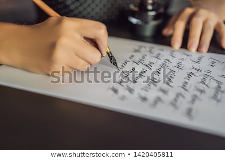 Сток-фото: Calligrapher Hands Writes Phrase On White Paper Bible Phrase About Love Inscribing Ornamental Decor