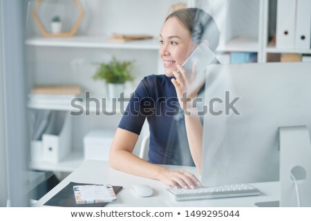 Zdjęcia stock: Happy Young Elegant Woman With Smartphone By Ear Working In Office