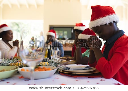 Stock fotó: Family Praying Before Meal At Christmas Dinner