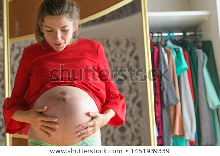 Foto d'archivio: Tight Pregnant Woman In Red Dress