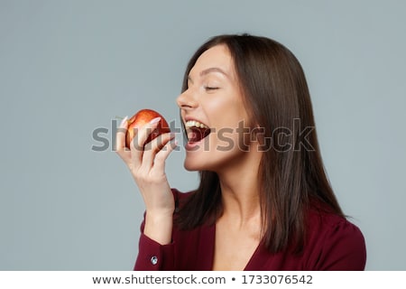 Foto stock: Young Woman Biting Red Apple Isolated On White