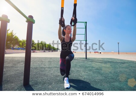 Stok fotoğraf: Women Doing Push Ups Training Arms With Trx Fitness Straps In Th
