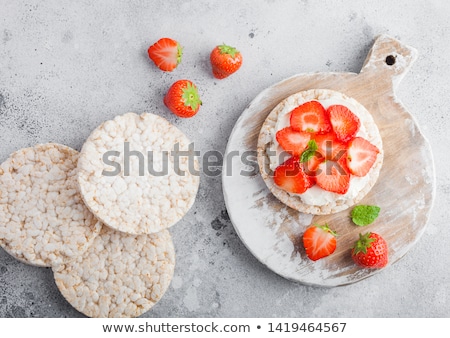 Foto stock: Healthy Organic Rice Cakes With Ricotta And Fresh Strawberries And Glass Of Milk On Light Stone Kitc