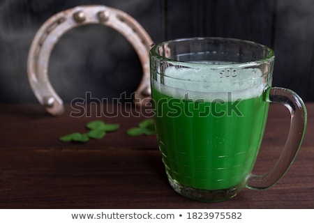 Foto stock: Shamrock On Glass Of Beer And Horseshoe On Table