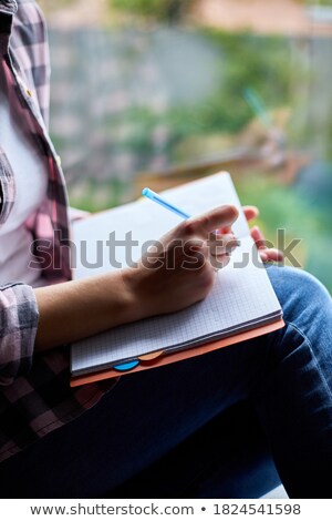 Stockfoto: Woman Sitting At Window At Home Writes In Notebook Goals