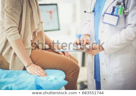 Stock foto: Woman Is Sitting On An Examination Table And Listening To A Doctor