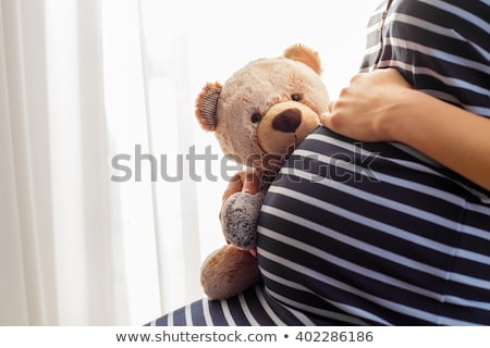 Foto stock: Pregnant Woman Holding Teddy Bear