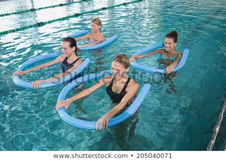 Stockfoto: Happy Fitness Class Doing Aqua Aerobics With Foam Rollers